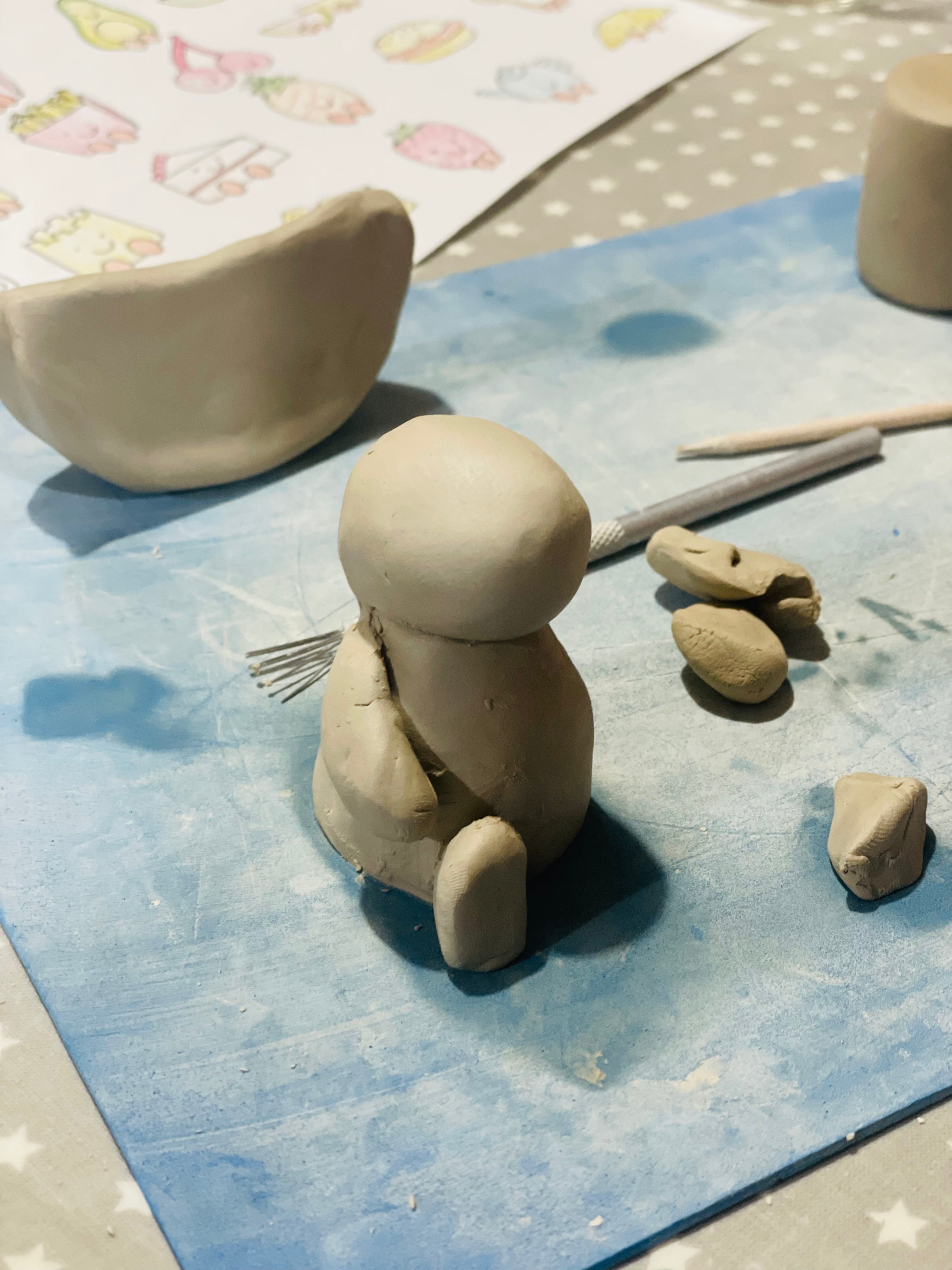 Clay jellycat sculpture with tools on a blue mat 