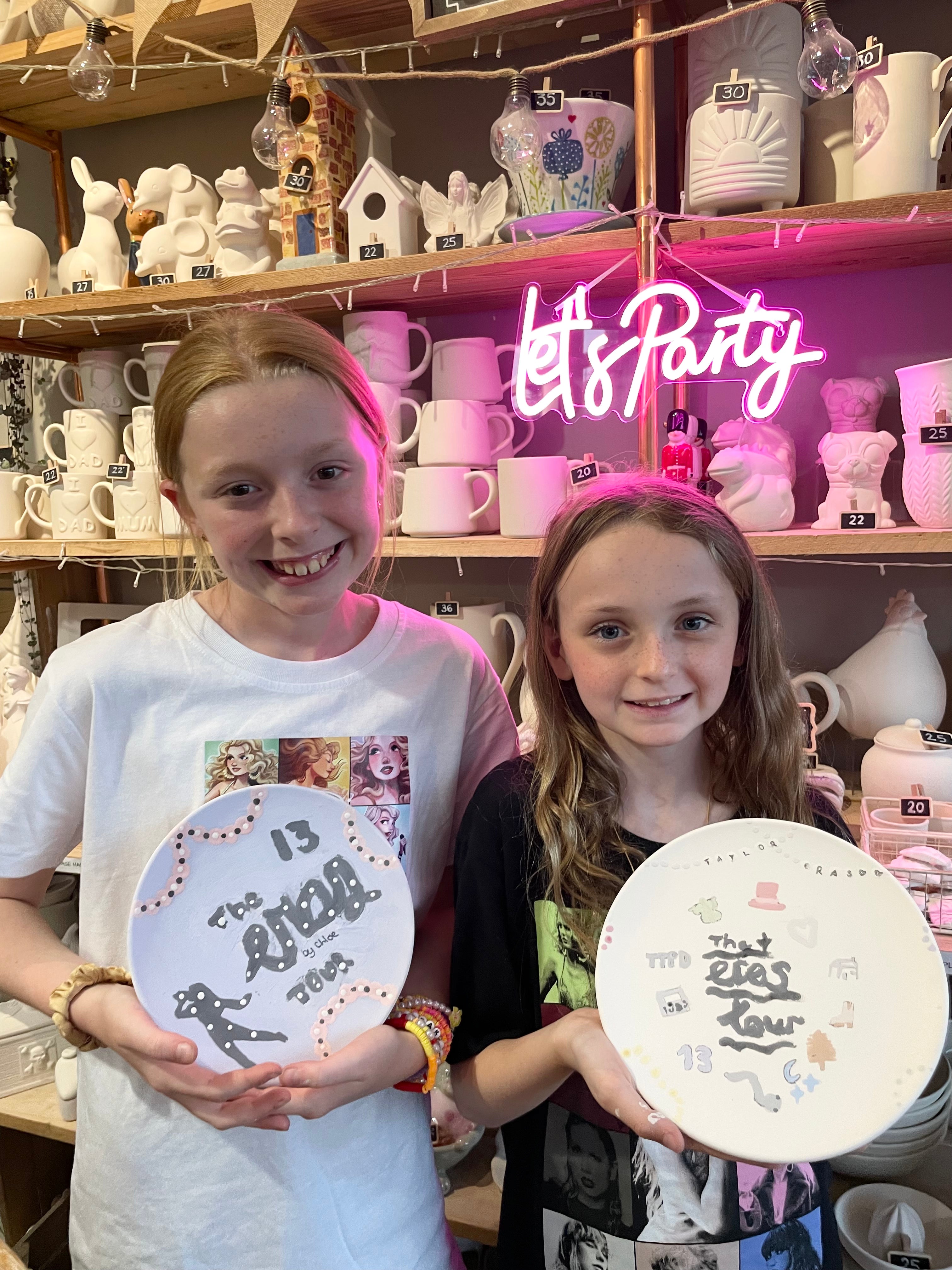 Two children holding taylor swift themed pottery painting plates at wick & ceramic ickenham london