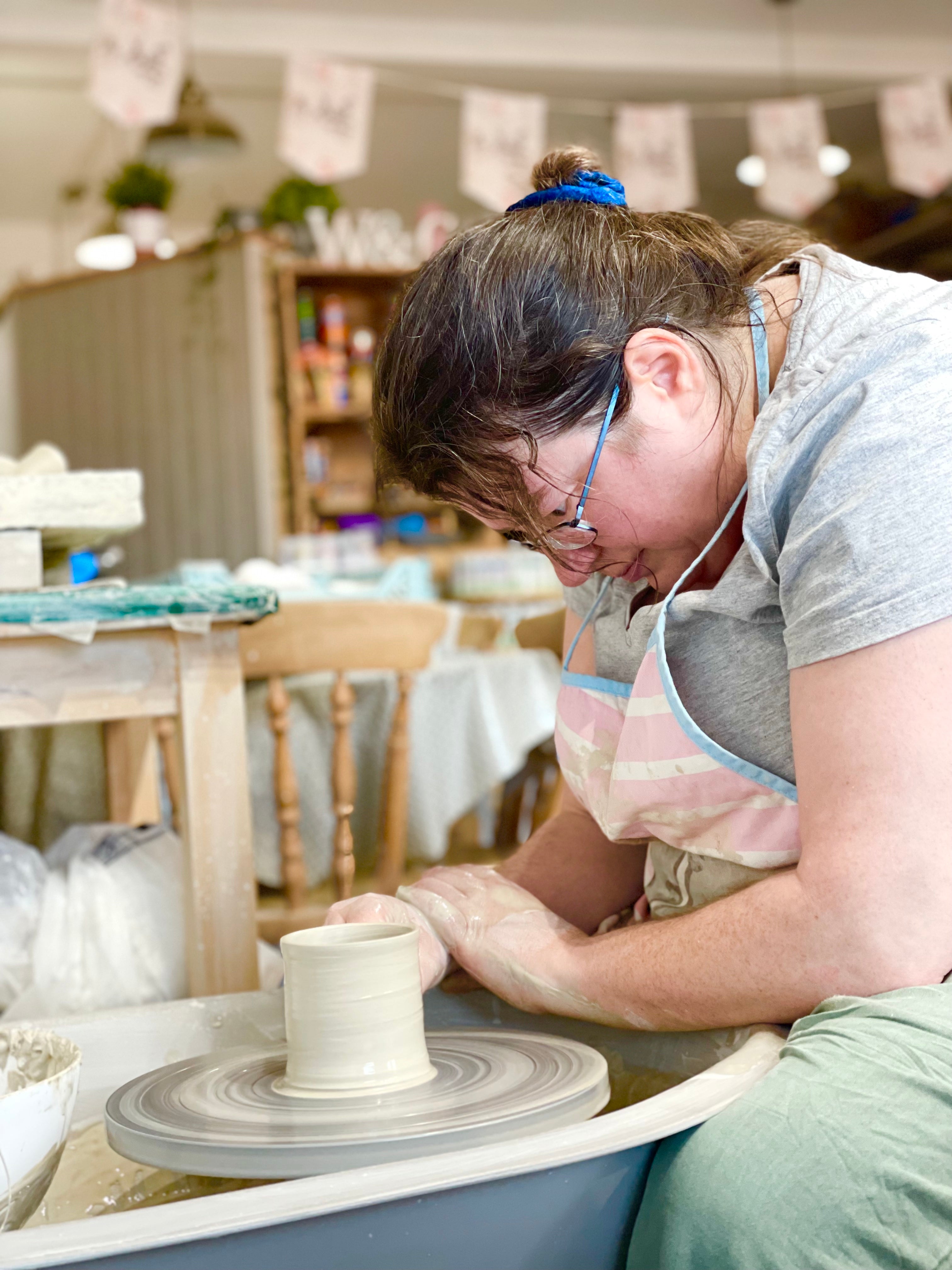 Lady working on a pottery wheel at Wick & Ceramic in Ickenham, London.