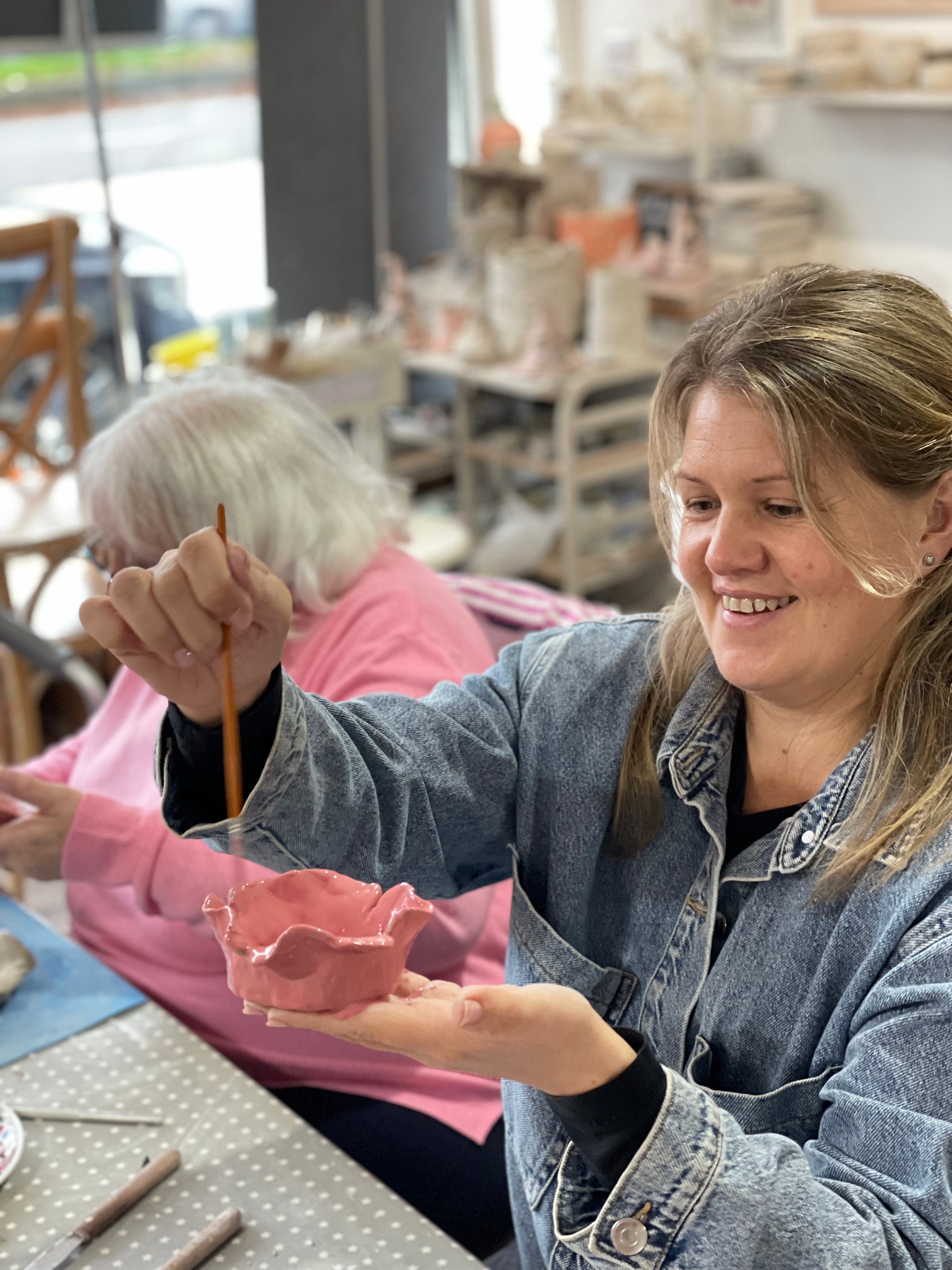 woman painting a ceramic poppy dish at wick & ceramic ickenham london