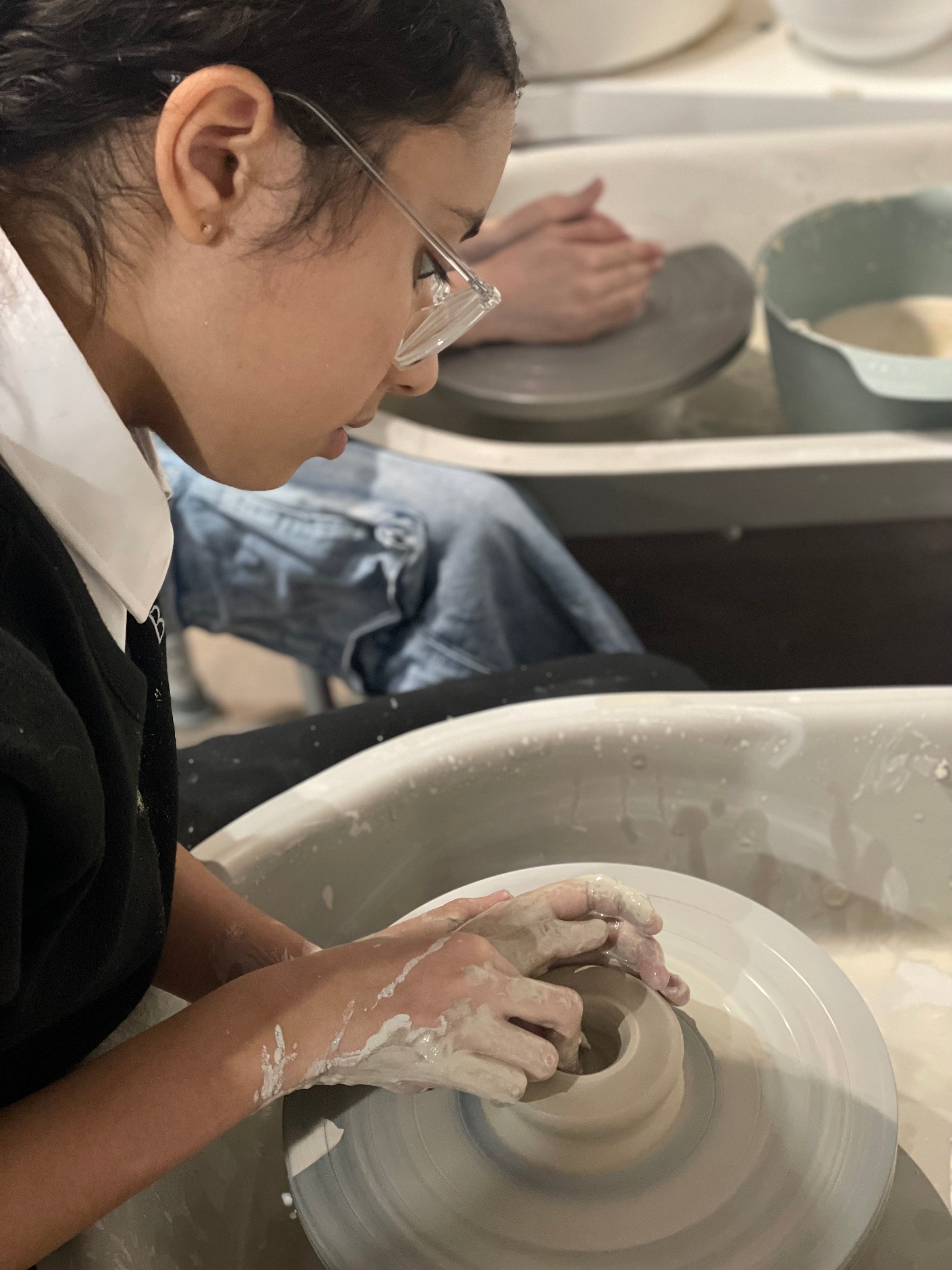 Young girl pottery making wheel throwing at Wick & Ceramic in Ickenham, London.